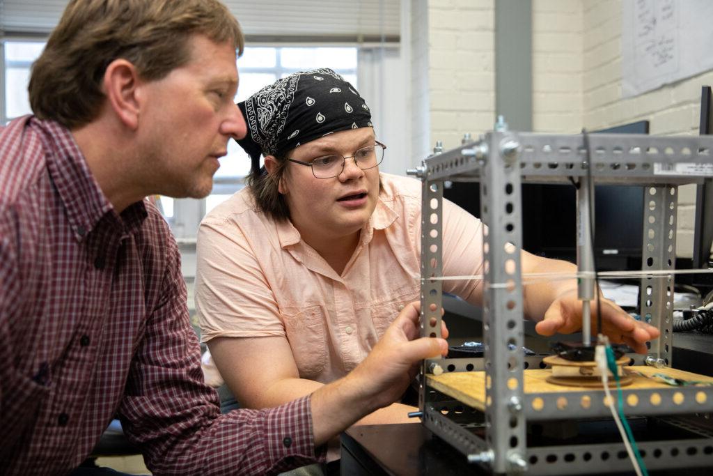 Physics and engineering professor Peter Sheldon works with a student on a project.