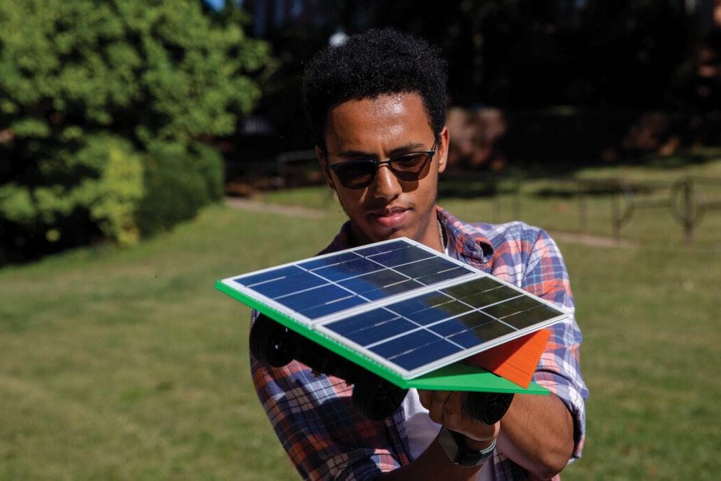 Randolph College student tests solar panel configurations on a model car.