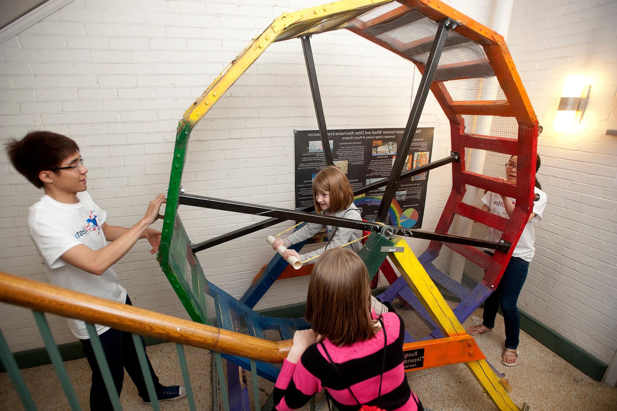 Randolph physics students demonstrate the Human Sized Hamster Wheel to local children during SciFest.